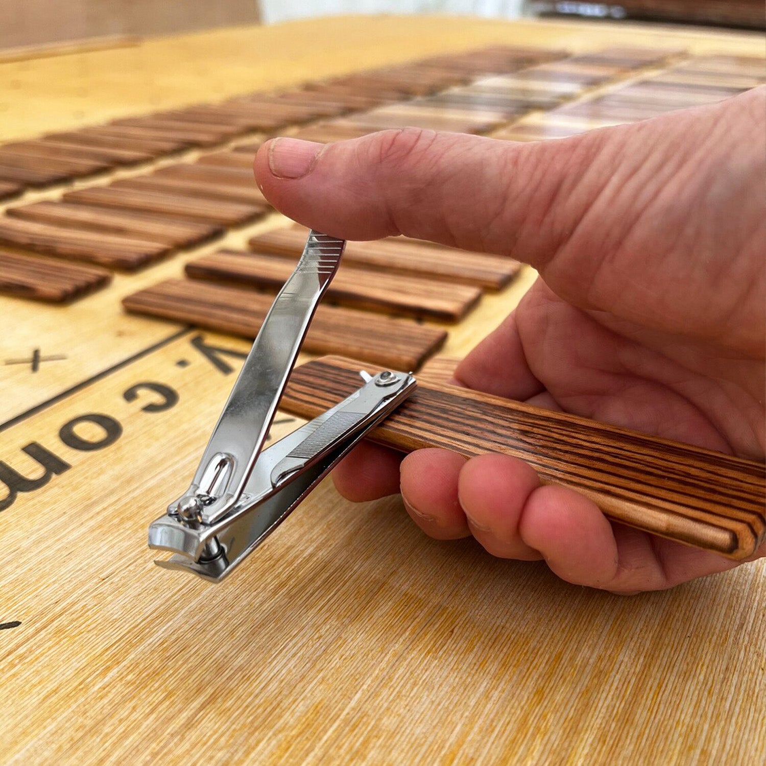 Person holding Multi-use nail clippers on wooden base showcasing accessibility, 